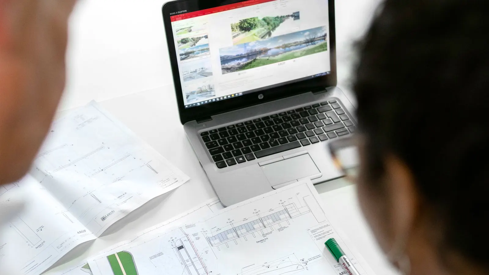 Profissionais com capacete analisam um projeto em um ambiente industrial
