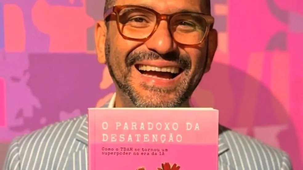Matheus Viana Machado segurando o livro O Paradoxo da Desatenção